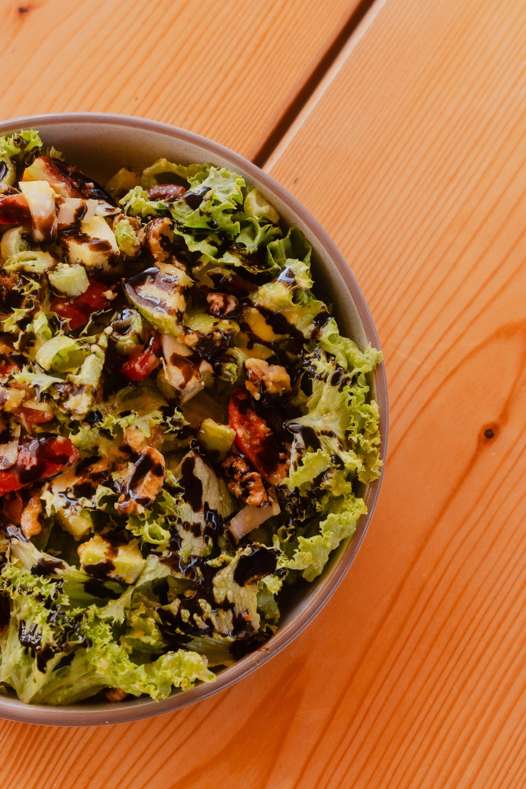Fresh green salad with walnuts, tomato and balsamic